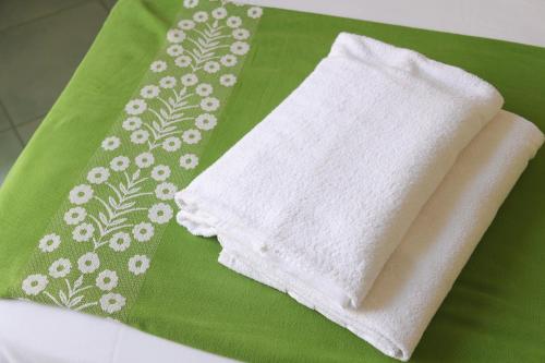 a white towel sitting on top of a green napkin at Hotel Pineta in Ischia