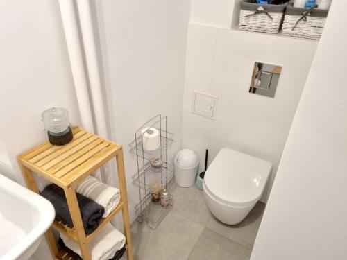 a white bathroom with a toilet and a sink at Apartament Miodowa Warszawa in Warsaw