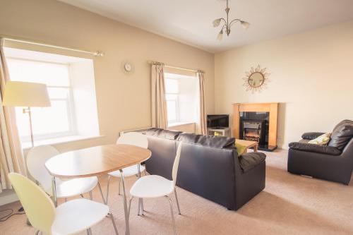 a living room with a couch and a table and chairs at Cathedral View Apartments in Longford