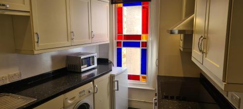 uma cozinha com um micro-ondas e um vitral. em Fore Street Bodmin em Bodmin