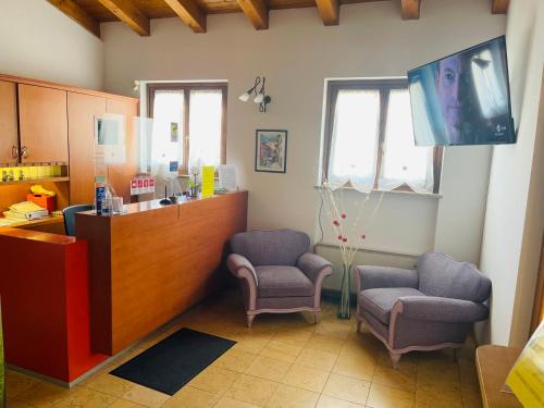 ein Wartezimmer mit zwei Stühlen und einer Theke in der Unterkunft Hotel Al Bosco in Sona