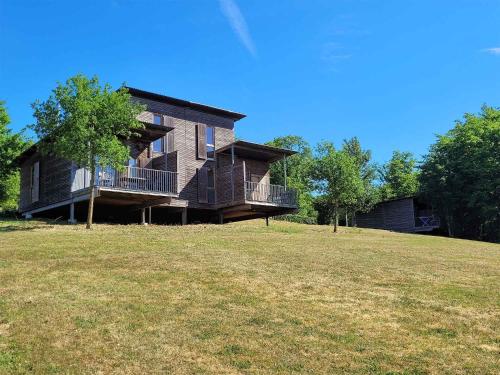 a large house on a hill with a yard at Madame Vacances Les Cottages De Valjoly in Eppe-Sauvage