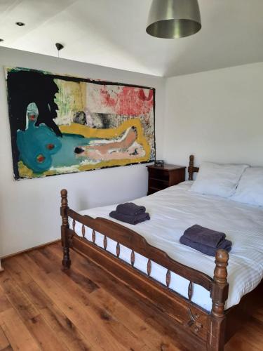 a bedroom with a bed with a painting on the wall at Arthouse Lola in Bergen
