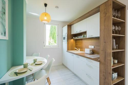 a kitchen with a table and chairs and a sink at Harmony Boutique Villa in Siófok