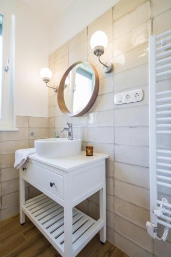 a bathroom with a white sink and a mirror at Harmony Boutique Villa in Siófok