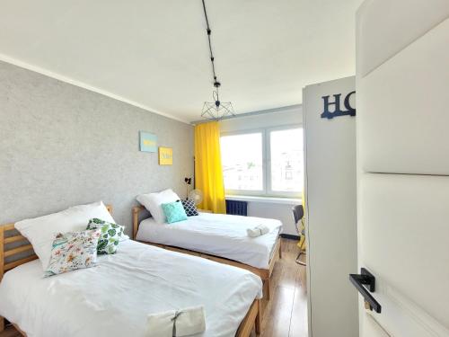um quarto com duas camas e uma janela em Pomorska Rooms em Łódź