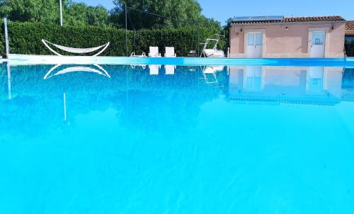 ノート・マリーナにあるLe Zagare di Vendicariの家の前の青い水の大きなプール