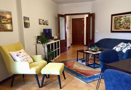 ein Wohnzimmer mit einem blauen Sofa und Stühlen in der Unterkunft El Angliru 3 con Wifi Incluido in Castandiello