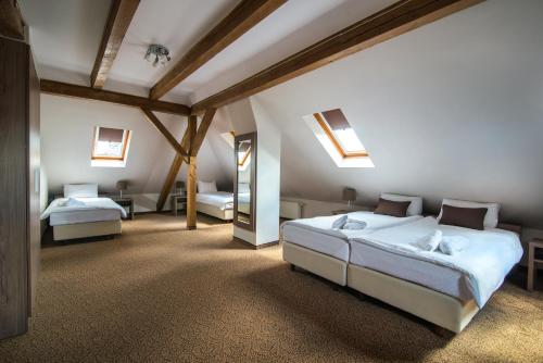 - une chambre avec 2 lits et un miroir dans l'établissement Hotel Biały Domek, à Wałcz