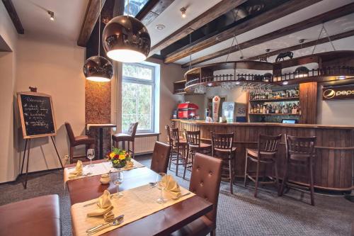 een restaurant met houten tafels en stoelen en een bar bij Hotel Biały Domek in Wałcz