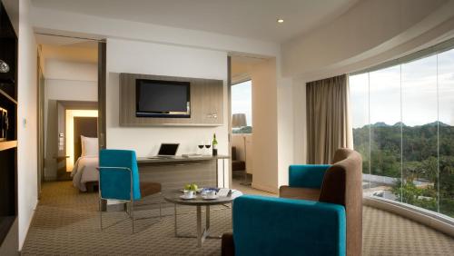 a hotel room with a bed and a table and chairs at Novotel Bangka Hotel & Convention Center in Pangkalpinang