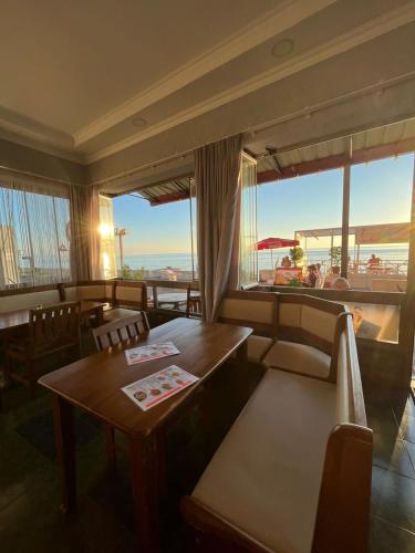 a restaurant with a table and chairs and a large window at Guest House Rusalka in K'obulet'i