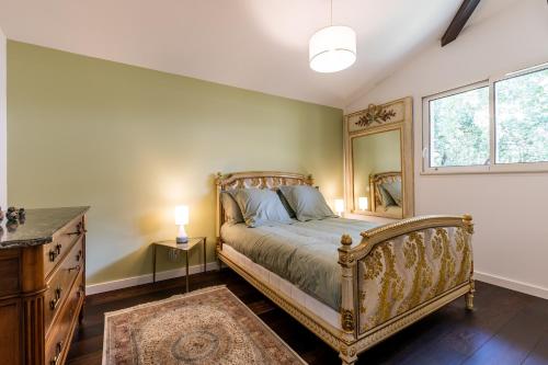 Schlafzimmer mit einem Bett, einer Kommode und einem Spiegel in der Unterkunft Villa Tilé Lanton in Lanton