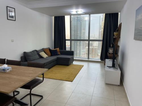 a living room with a couch and a large window at [METRO] Premium Location Lovely 2 Bedroom In JLT in Dubai