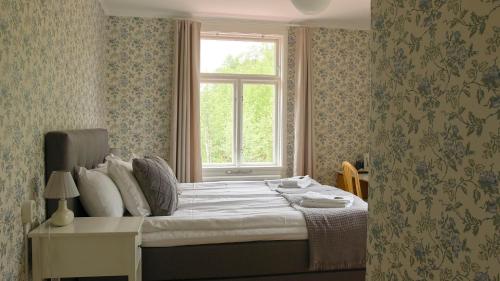 a bedroom with a large bed with a window at Alebo Pensionat in Unnaryd