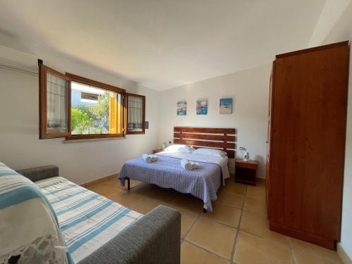 Un dormitorio con una cama y un sofá. en House 40 in Capannizza Pool Complex next the beach, en Budoni