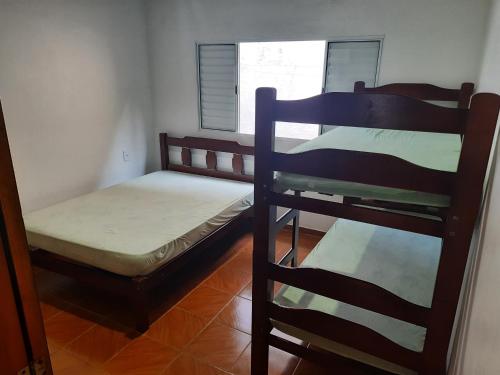 a room with two bunk beds and a window at Casa Ednalda in Ubatuba