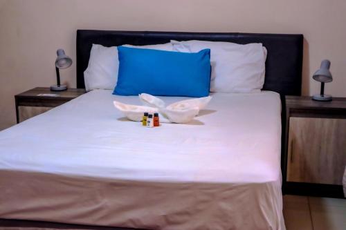 a bed with two bottles and two lamps on it at Amariah Guesthouse - Kazungula in Kasane