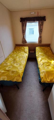 two beds in a small room with a window at Springs 46 by Vilija Southview Leisure Park Skegness in Skegness
