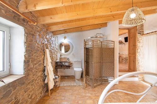 塔維拉的住宿－Quinta do Silêncio T2，一间带石墙和卫生间的浴室