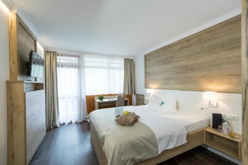 a hotel room with a bed with a teddy bear on it at AktiVital Hotel in Bad Griesbach