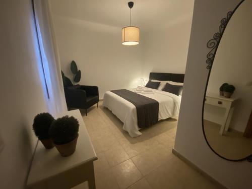 una camera d'albergo con letto e specchio di Villalia Capri a Playa Blanca