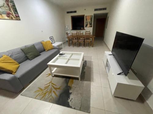 a living room with a couch and a table at METRO Premium Location Spacious 2 Bedroom Apartment Right Next to the Metro in Dubai