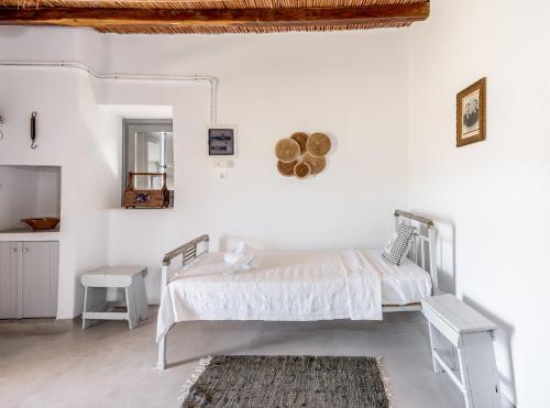 a white bedroom with a bed and a mirror at Olive Cottage in Zefiría