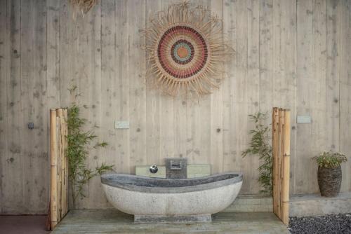 a bathroom with a tub and a wooden wall at Villa - Cantinho do Paraíso in Santo Espírito