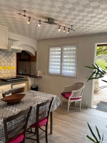 une cuisine et une salle à manger avec une table et des chaises dans l'établissement Les palmiers, à Fréjus