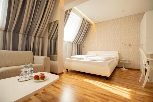 una camera da letto con un letto, un divano e un tavolo di Hotel Gollner a Graz