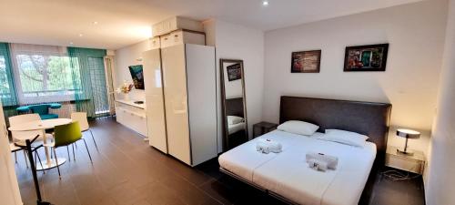 a hotel room with a bed and a table and chairs at Bissone Apartment in Bissone