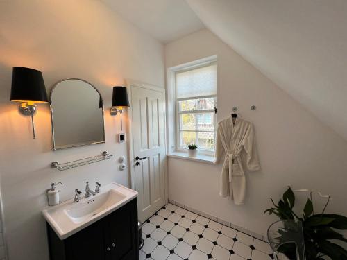 een badkamer met een wastafel en een raam bij stilvolle Ferienwohnung Sweet Magnolia in Kühlungsborn