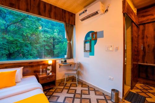 a bedroom with a bed and a large window at Zostel Rishikesh, Laxman Jhula in Rishīkesh