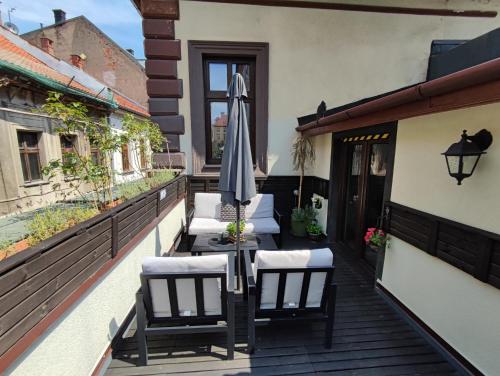 a patio with an umbrella and chairs on a balcony at Apartament Podcienie z tarasem Bielsko-Biała Old Town in Bielsko-Biala