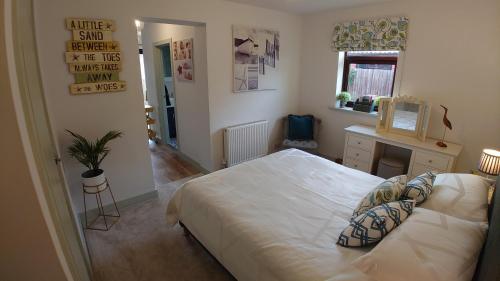 a bedroom with a large bed and a desk at Avocet Lodge, Snettisham in Kings Lynn