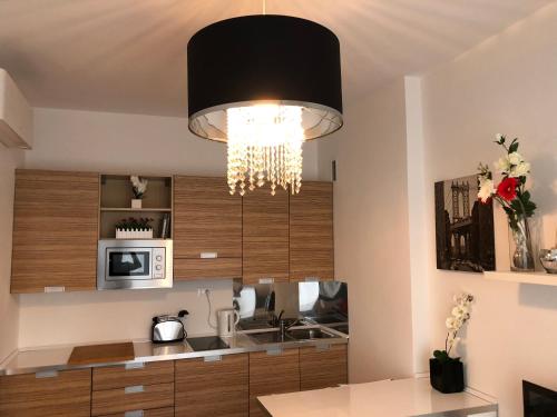 een keuken met een kroonluchter aan het plafond bij Your best apartment in Abano Terme in Abano Terme