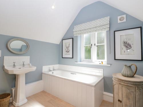 a bathroom with a bath tub and a sink at Number 29 in Malvern Link
