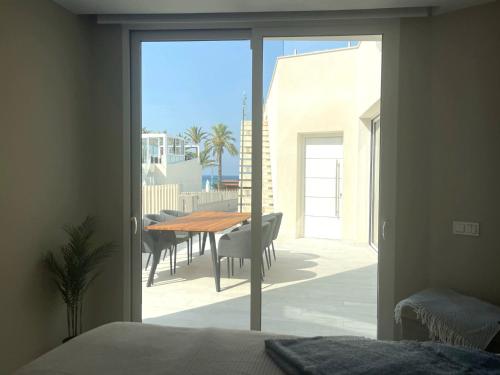 a bedroom with a view of a patio with a table at Casa Mirabelle, a La Azohia dream by the sea in Cartagena