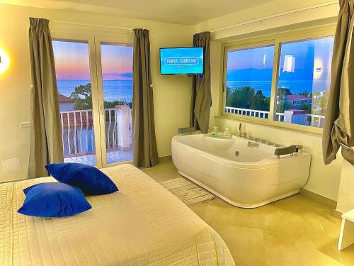 a bedroom with a large bath tub and a television at Imperial Rooms Tropea in Tropea