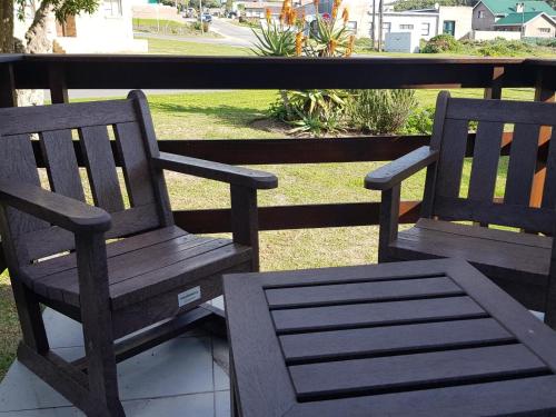 two wooden benches sitting on top of a porch at 4 On Hoffman Seaview in Agulhas