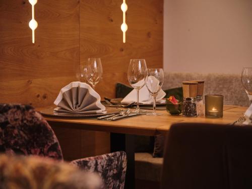 a table in a restaurant with wine glasses on it at Sporthotel Wagrain in Wagrain