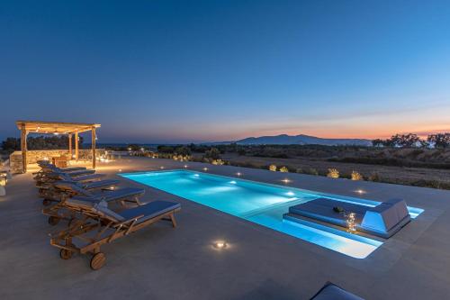 a villa with a swimming pool at night at Villa Armelina in Plaka