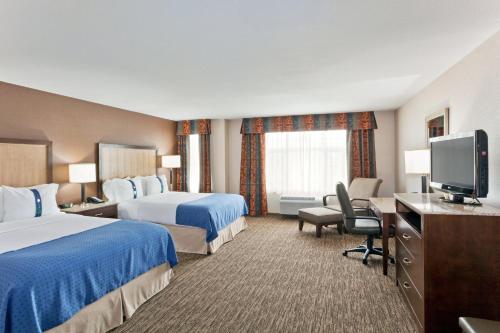 a hotel room with two beds and a flat screen tv at Holiday Inn Hotel & Suites Surrey East - Cloverdale, an IHG Hotel in Surrey