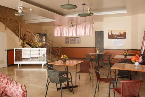 a restaurant with tables and chairs and a staircase at GV Hotel - Baybay in Baybay