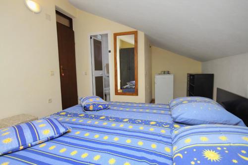 a bedroom with a large bed with blue sheets and pillows at Double Room Njivice 5458a in Njivice