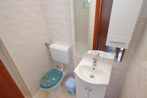 La petite salle de bains est pourvue de toilettes et d'un lavabo. dans l'établissement Apartment Njivice 5458b, à Njivice