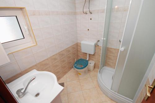 a bathroom with a shower and a sink and a toilet at Apartment Njivice 5458e in Njivice