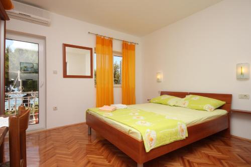 ein Schlafzimmer mit einem Bett und einem großen Fenster in der Unterkunft Studio Drvenik Donja vala 6658a in Drvenik