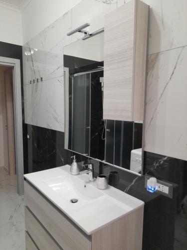 La salle de bains est pourvue d'un lavabo et d'un miroir. dans l'établissement DREAM HOUSE, à Lido di Ostia